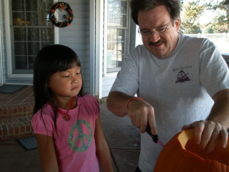 Kasen watching Daddy carve the pumpkin